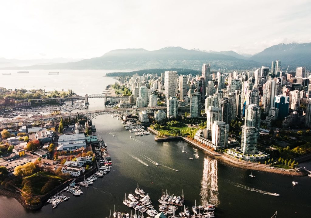 The downtown core and harbour of Vancouver from a bird's eye view, the mountains in the background.